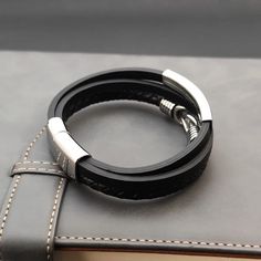 This stylish triple layer leather bracelet is crafted with high quality stainless steel and PU materials. The combination of stainless steel and PU makes it durable and comfortable to wear. Elevate any outfit with this must-have accessory. Modern Black Braided Bracelets With Stainless Steel Clasp, Modern Black Braided Bracelet With Leather Strap, Black Minimalist Braided Stainless Steel Bracelets, Black Leather And Stainless Steel Adjustable Bracelet, Minimalist Black Stainless Steel Braided Bracelets, Black Stainless Steel Wristband, Modern Leather Bracelet With Metal Black Band, Modern Metal Leather Bracelet With Black Band, Modern Stainless Steel Braided Bracelets For Everyday