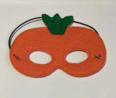 an orange mask with a green leaf on it