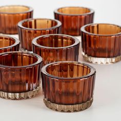 several brown glass cups sitting next to each other