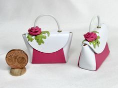 two small purses with flowers on them next to a penny