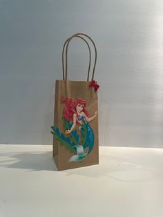 a brown paper bag with a little mermaid on it