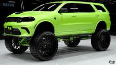 a bright green pick up truck is parked in a garage with black tires and rims