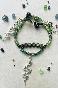 a bracelet with beads and charms on it, including the word army written in white letters