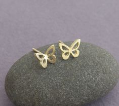 "14k gold butterfly stud earrings. Pretty and dainty earrings, handmade of solid 14k gold. I cut each butterfly with a jeweler's saw, from a solid gold sheet, file it, and solder a 14k gold post to the back of each one. I give the small butterflies a shiny mirror-like finish. You can choose between a few options: A cute mismatched pair - one butterfly flat and the other is with raised wings. A pair of flat earrings. Or pair with raised wings. Butterflies symbolize hope, transformation, rebirth a 14k Gold Butterfly Charm Earrings, 14k Gold Butterfly Earrings With Butterfly Charm, 14k Gold Butterfly Earrings With Charm, 14k Gold Butterfly Earrings For Gift, 14k Gold Butterfly Earrings For Anniversary, Minimalist Butterfly Charm Earrings, Minimalist Butterfly Charm Earrings For Gift, Minimalist Butterfly Charm Earrings Gift, Dainty Yellow Gold Butterfly Earrings