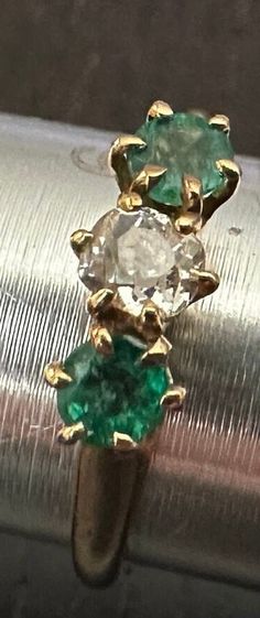 Antique 14K Emerald & Diamond ring size 6, weight 2.2 grams.  Antique old white European cur center Diamond(4mm-approx 1/4 carat) with two genuine richly colored deep green Emeralds on each side-High prong setting.  The classic trinity horizontal design. Classic Green Multi-stone Emerald Ring, Antique Green Oval Diamond Ring, Classic Green Jewelry With Rose Cut Diamonds, Antique Green Emerald Ring With Prong Setting, Antique Emerald Diamond Ring For Formal Occasions, Antique Green Diamond Ring For Formal Occasions, Antique Round Emerald Ring With Diamonds, Multi-stone Round Cut Emerald Ring, Emerald Multi-stone Round Cut Ring