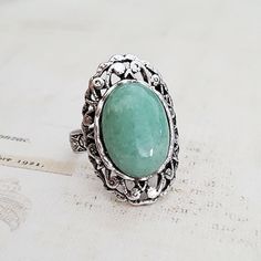 Natural green aventurine cabochon on a sturdy vintage style adjustable silver plated setting.  The ring is adjustable to fit approx size 6 upwards, and has a comfortable, floral patterned band. The cabochon is 3/4 inch (18 mm) from top to bottom. It is a mid to heavier weight ring. The ring has a chunky, vintage feel.  This ring is gift boxed. More rings are here: http://etsy.me/230E2um Vintage Adjustable Emerald Ring, Green Aventurine Jewelry, Aventurine Ring, Aventurine Jewelry, Aventurine Stone, Ring Antique, Cabochons Stones, Lovely Necklace, Silver Filigree