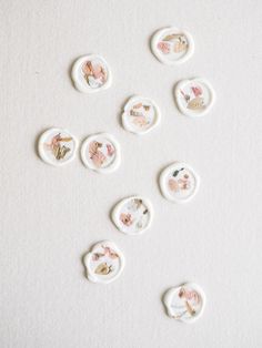 some white buttons with pink flowers on them