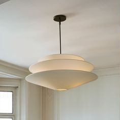 a light fixture hanging from the ceiling in a room with white walls and flooring