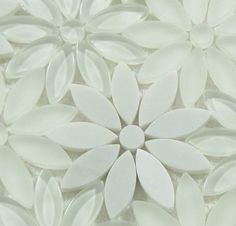 a close up view of white flowers on a tile floor with no one around them