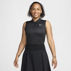 a woman in a black and white tennis dress smiles at the camera while standing with her hands on her hips