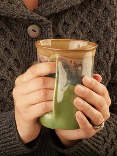 a woman holding a cup in her hands