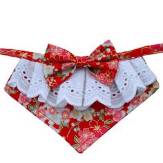 a red bandana with white laces and bows on it's neckline