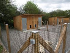 a fenced in area with several wooden buildings