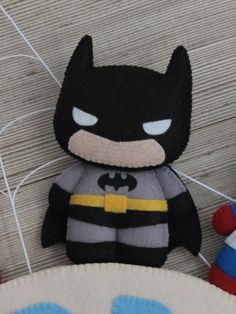 a batman stuffed animal sitting on top of a wooden floor