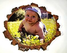 a baby is laying in the grass and looking at the camera with a hat on his head