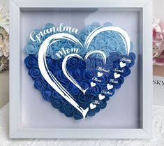 a blue and white paper heart in a shadow box