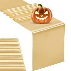 a carved pumpkin sitting on top of a piece of plexed paper next to a stack of wooden planks