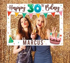 two women holding up a sign that says happy 30th birthday marcus with candles in front of them