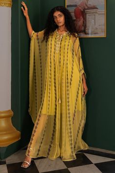 Yellow evil eye print full length kaftan with pleat details in the front and back and cutdana and bead embellished neckline. Paired with an inner.
Components: 2
Pattern: Printed
Type Of Work: Cutdana, Bead
Neckline: Round
Sleeve Type: Long
Fabric: Chiffon
Color: Yellow
Other Details: 
Attached lining
Occasion: Resort - Aza Fashions Silk Maxi Length Abaya, Eid Chiffon Maxi Abaya, Chiffon Long Maxi Dress For Eid, Long Sleeve Georgette Kaftan For Eid, Bohemian Floor-length Georgette Maxi Dress, Long Chiffon Kaftan For Eid, Flowy Floor-length Kaftan, Flowy Maxi Length Kaftan For Eid, Bohemian Long Georgette Dress