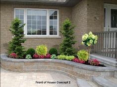 the front of a house with flowers and trees in it's flowerbeds