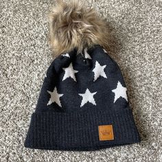 a blue hat with white stars on it and a brown pom - pom