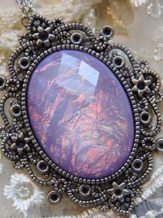 JUST LISTED - Vintage Inspired - Georgian & Victorian Cameo Jewlery - Lavender purple Moonstone FIre Opal OOAK Victorian princess Fantasy glass art Mythical Necklace Altered Art substantial in size at just a little over 2 INCHES Long Center is 40mmx30mm **thank you for taking the time to look at our items. Each item is handcrafted and attention to detail - We send each item in bubble packaging and with tracking to make sure items arrive in perfect condition. Please feel free to check out our Handmade Purple Fantasy Necklaces, Handmade Purple Fantasy Necklace, Purple Fantasy Necklace For Gift, Fantasy Style Purple Necklace For Gift, Artistic Purple Pendant Jewelry, Artistic Round Purple Jewelry, Victorian Princess, Bubble Packaging, Princess Fantasy