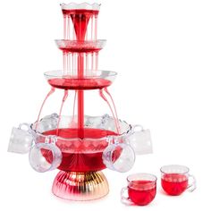 a red three tiered glass tea set with cups and saucers