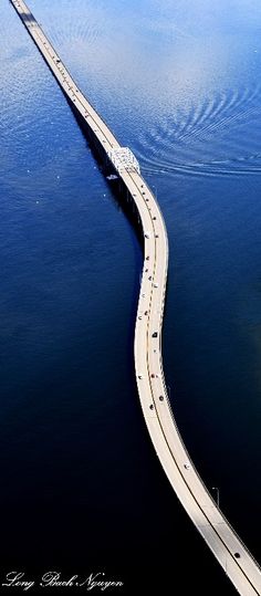 an aerial view of a long bridge over water