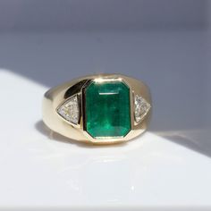 Emeralds are one of nature’s masterpieces—known as “The Jewel of Kings” this gem has been long regarded as a superior stone throughout the ages. Our impressive emerald is framed by just the right amount of sparkle and set in buttery warm gold that glows on wearers hand, making it the perfect statement piece for every body. 3.21 ct Zambian Emerald .60 tcw trillion diamonds 14k yellow gold Band measures 5mm, tapers to 13.4mm face Size 7, sizable Made by Private Label for Good Fortune in Los Angele Luxury Gia Certified Emerald Cut Gemstones, Luxury Gia Certified Emerald Gemstones, Luxury Oval Emerald Gemstones, Luxury Yellow Gold Gia Certified Gemstones, Luxury Gia Certified Yellow Gold Gemstones, Luxury Emerald Cut Gemstone With 17 Jewels, Luxury Trillion Cut Emerald Ring For Formal Occasions, Luxury Green Gemstones For Anniversary, Luxury Gia-certified Trillion Cut Emerald Ring