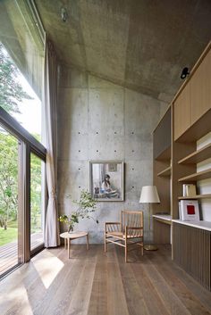 a living room with wooden floors and shelves on the wall next to a large window