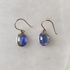 ITEM DESCRIPTION: >> The earrings are made from Solid 14K Yellow Gold. Gemstone used is absolutely natural and ethically sourced. >> Naturally occurring Bi-color Tanzanite Cabochon with shades of blue and green in bezel setting is studded on it with utmost precision.  >> This is a minimalist design and is absolutely hassle-free and everyday jewelry.  Gem: Bi-color Tanzanite Gem size: 8x10 mm Oval Gem weight: 6.96 carats Gold purity: 14K (58.33% approx.) Gold weight: 0.55 grams  Gross weight: 1.94 grams The Gold purity is guaranteed and it comes with authentic 14K gold hallmark. Since these Earrings are handmade, they are Nickel/Lead FREE.  CUSTOMISATION: --> Earrings can be made in thicker bezel as well. --> Earrings can be made with Lever Back Closure as well. It will cost extra $50 USD. Oval Tanzanite Gemstone Earrings, Fine Jewelry Oval Earrings With High Luster, Oval Gemstone Earrings In 14k Gold, 14k Gold Oval Gemstone Earrings, Formal 14k Gold Earrings With Ethical Gemstones, Tanzanite Round Earrings As Gifts, Round Tanzanite Earrings Gift, Tanzanite Teardrop Earrings As A Gift, Round Tanzanite Earrings For Gifts