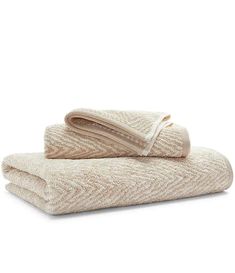 two towels folded on top of each other, one in beige and the other in white