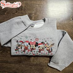 Christmas Mickey And Friends Embroidered Sweatshirts Introducing our Embroidered Sweatshirts – the ideal blend of comfort and sophistication. Made from a high-quality, soft cotton-blend fabric, these sweatshirts are designed to keep you warm while adding a stylish touch to your outfit. Each sweatshirt boasts detailed embroidery, bringing a hint of elegance and uniqueness that transforms... Christmas Disney Outfits, Disney Christmas Outfits, Friends Embroidery, Gingerbread Santa, Disney Christmas Shirts, Simple Sweatshirt, Christmas Mickey, Disney Sweaters, Embroidered Sweatshirt