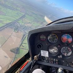 the view from inside an airplane looking down on fields and farmlands in the distance