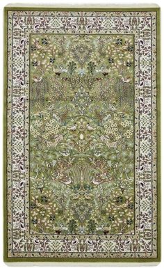 a green rug with an ornate design on the bottom and sides, in various colors