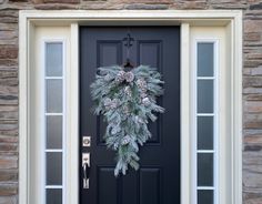 a black front door with a wreath on it