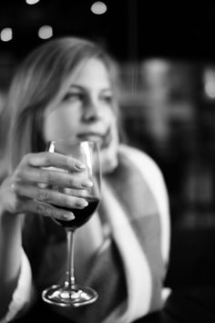 a woman holding a wine glass in her hand