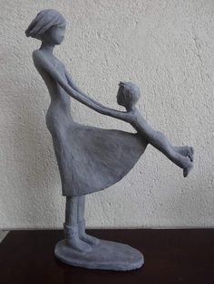 a statue of a woman holding a baby in her arms on top of a table