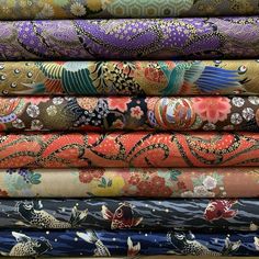 many different colored fabrics are stacked together