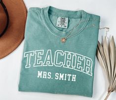 NEXT DAY SHIPPING! Printed on Comfort Colors® tees for that soft, vintage look and feel. 💖 Custom Teacher Shirt, Comfort Colors Teacher Tee, Personalized Teacher Gift, Teacher Appreciation, Back to School, New Teacher Gift, Teacher, Custom Teacher Name, Teacher Name Shirt, 1st day of school, Mrs Teacher Shirt Production Time: 1-2 days Shipping Time: 2-5 business days Product Details: Comfort Colors® 1717 Unisex Garment-Dyed T-shirt Relaxed Fit Made 100% with ring spun cotton DTG (Direct To Garm Vintage College T-shirt With Lettering, Vintage Short Sleeve Tops With Lettering, Retro Crew Neck T-shirt For Teacher Appreciation, Vintage Letter Print T-shirt For Everyday, Vintage T-shirt With Lettering For College, Vintage Lettering T-shirt For College, Teacher Team Shirts, New Teacher Gift, Teacher Custom