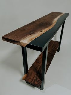 a wooden table with black metal legs and a wood slab on the top that is shaped like a boat