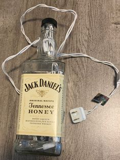 a bottle of jack daniels honey sitting on top of a wooden table next to an mp3 player