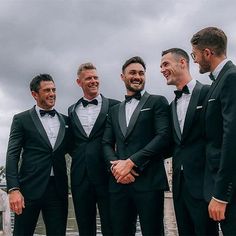 a group of men in tuxedos standing next to each other