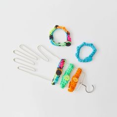 several different types of bracelets and hooks on a white surface with one being made out of plastic beads