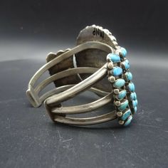 "VINTAGE NAVAJO BRACELET DESCRIPTION: This dynamic cuff features round and teardrop shaped specimens of natural blue turquoise set in micro-serrated bezel. This outstanding bracelet will be a cherished addition to your collection of the very finest vintage Native American jewelry. MEASUREMENTS: Interior of the cuff measures 6 1/8\" with an additional 1 1/4\" non-adjustable gap. Total circumference: 7 3/8\" Measures 2 3/4\" straight across the widest part (from wrist bone to wrist bone) Bracelet Antique Turquoise Bangle, Vintage Turquoise Round Cuff Bracelet, Vintage Turquoise Oyster Bracelet, Vintage Blue Cuff Jewelry, Blue Oval Vintage Cuff Bracelet, Vintage Adjustable Gemstone Cuff Bracelet, Vintage Gemstone Cuff Bracelet Collectible, Adjustable Vintage Gemstone Cuff Bracelet, Bone Bracelet