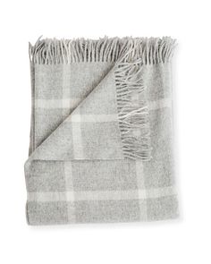 a gray and white plaid blanket with fringes