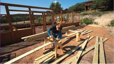 a man is working on some wood in the middle of a construction site with other wooden structures