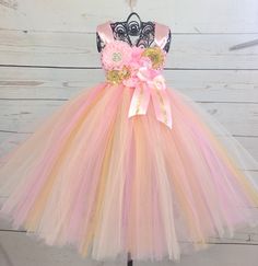 *Please check turn around times. All items are made to order* This listing is for a pink and gold tutu dress that is simply stunning. Made with pink, gold, and ivory tulle. Bodice is adorned with multiple styles of different colored flowers to match. Comes with pink satin straps that criss crosses in the back to form a bow. I will need 3 measurements. 1. length - measure from waist to knees (or desired length if you would like it longer). This measurement will go in the drop down box under lengt Gold Flower Girl Dress, Gold Tutu Dress, Pink And Gold 1st Birthday, Tutu Dress Pink, Gold Flower Girl, Cream Butterfly, 1st Birthday Dress, Tulle Bodice, Pink And Gold Birthday