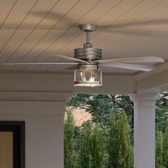 a ceiling fan on the outside of a house with trees in the backgroud