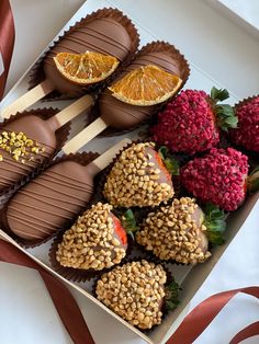 chocolate covered strawberries and oranges in a box with red ribbon on the side